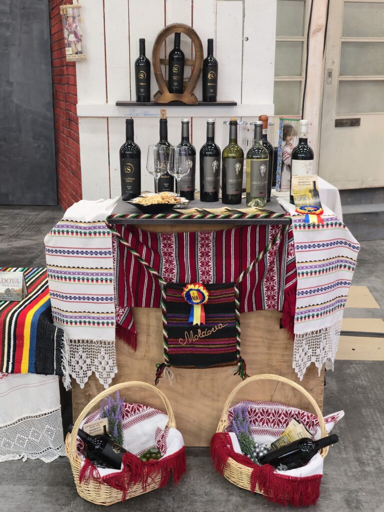 Flaschen Wein stehen auf einem moldawisch-gedeckten Tisch. Auch in Körben vor den Tischen ist Wein